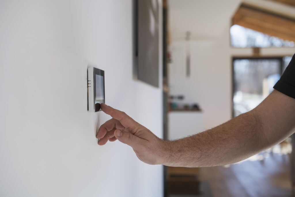 Man at home adjusting a thermostat
